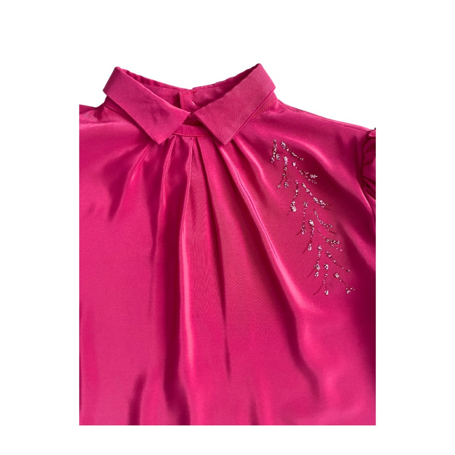 Pink blouse with a collar and decorative elements on a white background