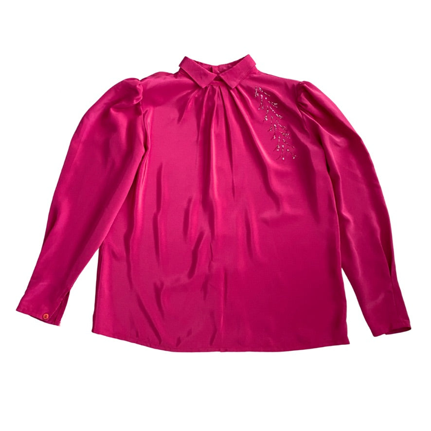 Pink blouse with long sleeves and decorative elements on a white background