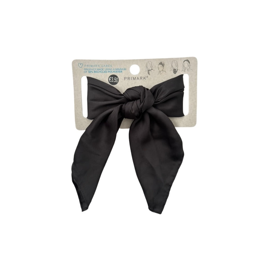 Black hair bow on a Primark branded card against a white background
