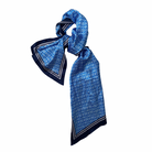 A blue scarf with a geometric bordered pattern, displayed on a white background.