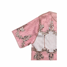 Pink top fabric with intricate silver embroidery on a white background
