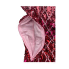 Close-up of a zip opening on red sequin garment with a pink lining on a white background
