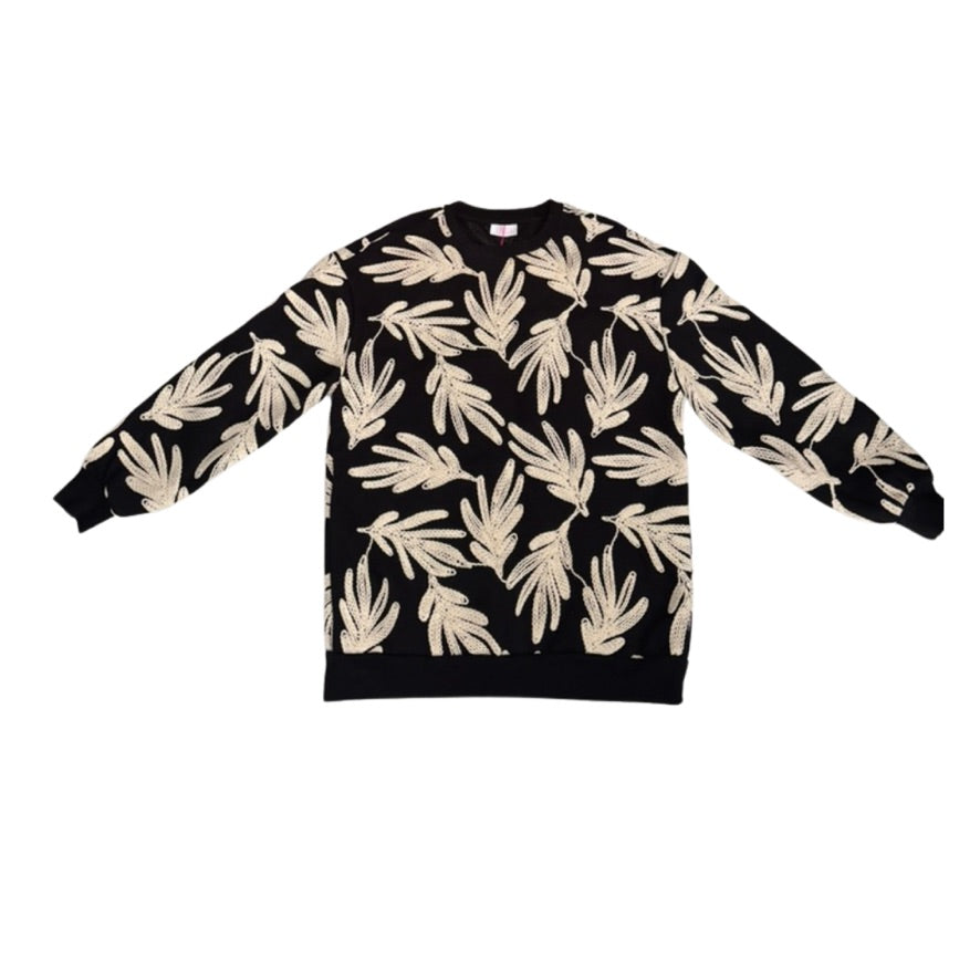 Black sweater with beige leaf pattern on a white background