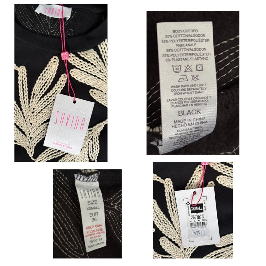 Clothing label with brand name and size information on a black garment with white embroidery.