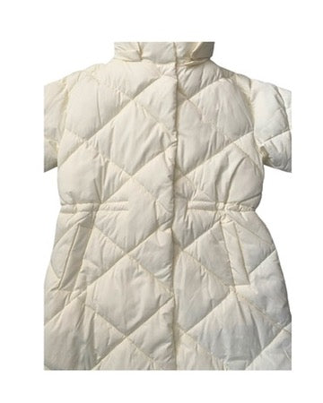 Cream quilted coat close-up on a white background