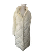 White quilted puffer vest on a mannequin against a white background