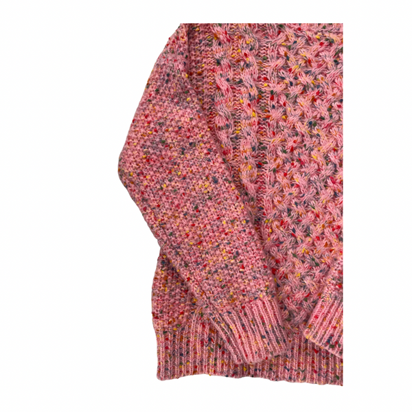 Close-up of a pink knitted sweater with a pattern on a white background