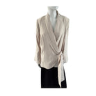 Beige wrap-style top on a mannequin against a white background
