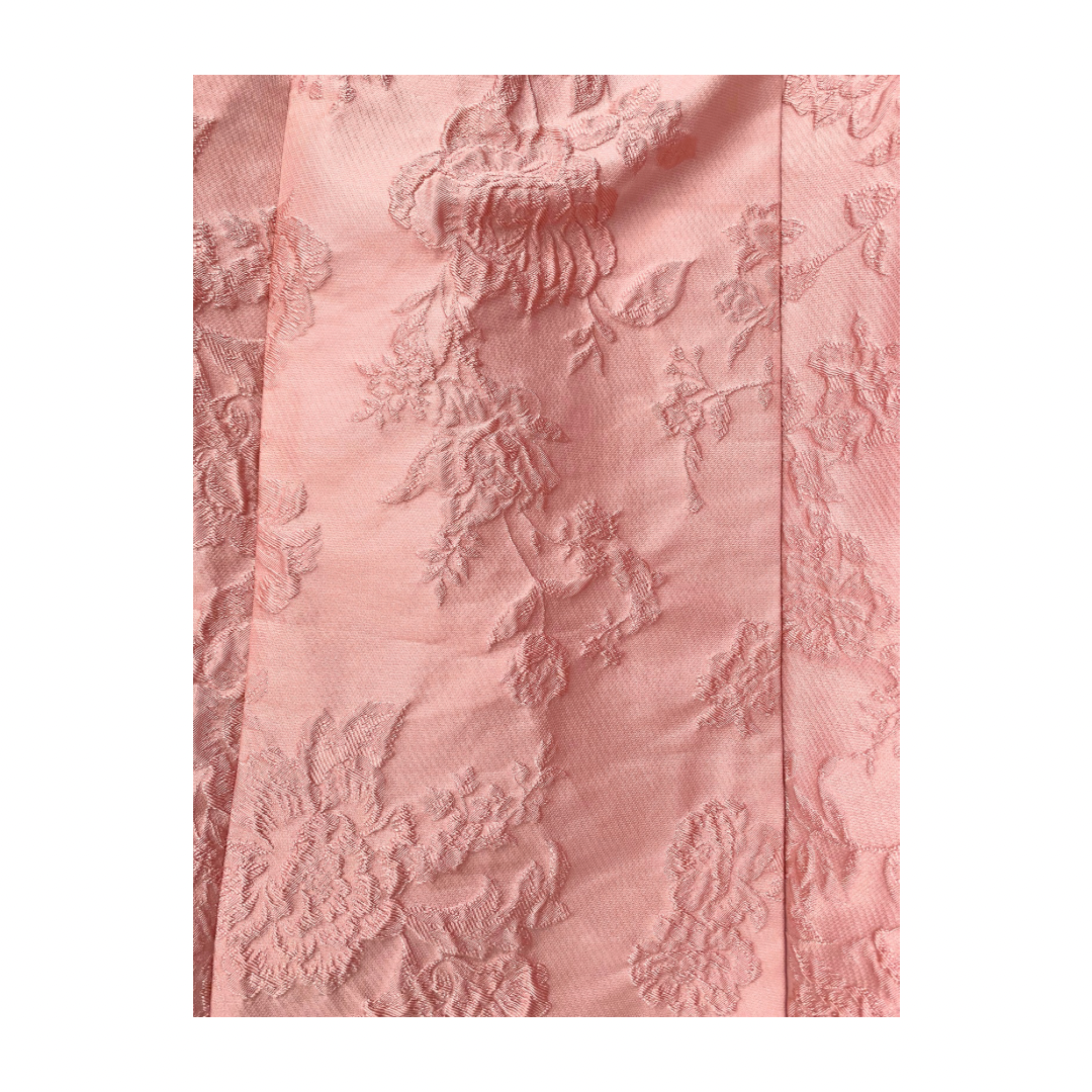 Pink textured fabric with floral patterns on a white background