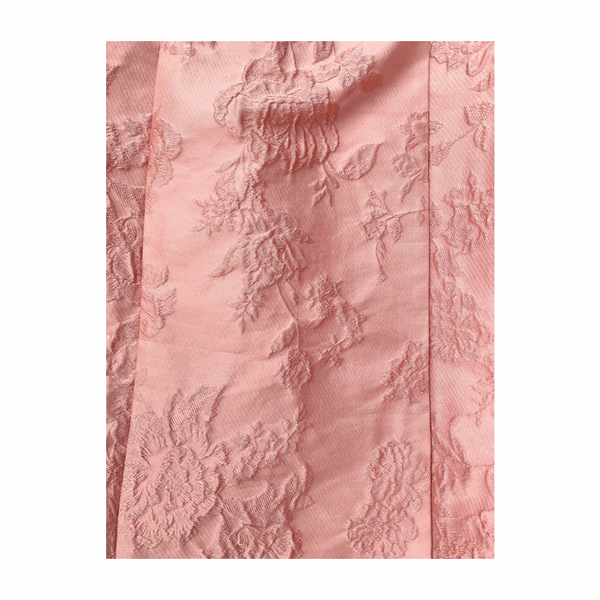 Pink textured fabric with floral patterns on a white background