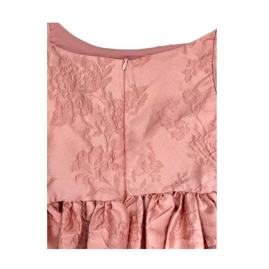 Pink floral dress close-up with a textured pattern on a white background