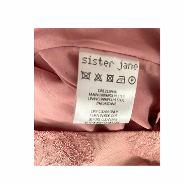 Label on a pink garment with 'sister jane' branding