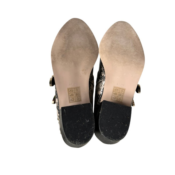 Black shoes with soles showing wear on a white background