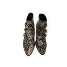 Snakeskin-patterned boots with buckles on a white background