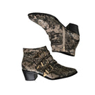 Snakeskin-patterned ankle boots with gold buckles on a white background