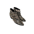 Pair of snake print ankle boots on a white background