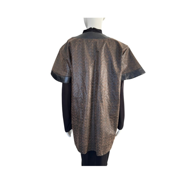 Mannequin wearing a patterned poncho with leather trim on a white background