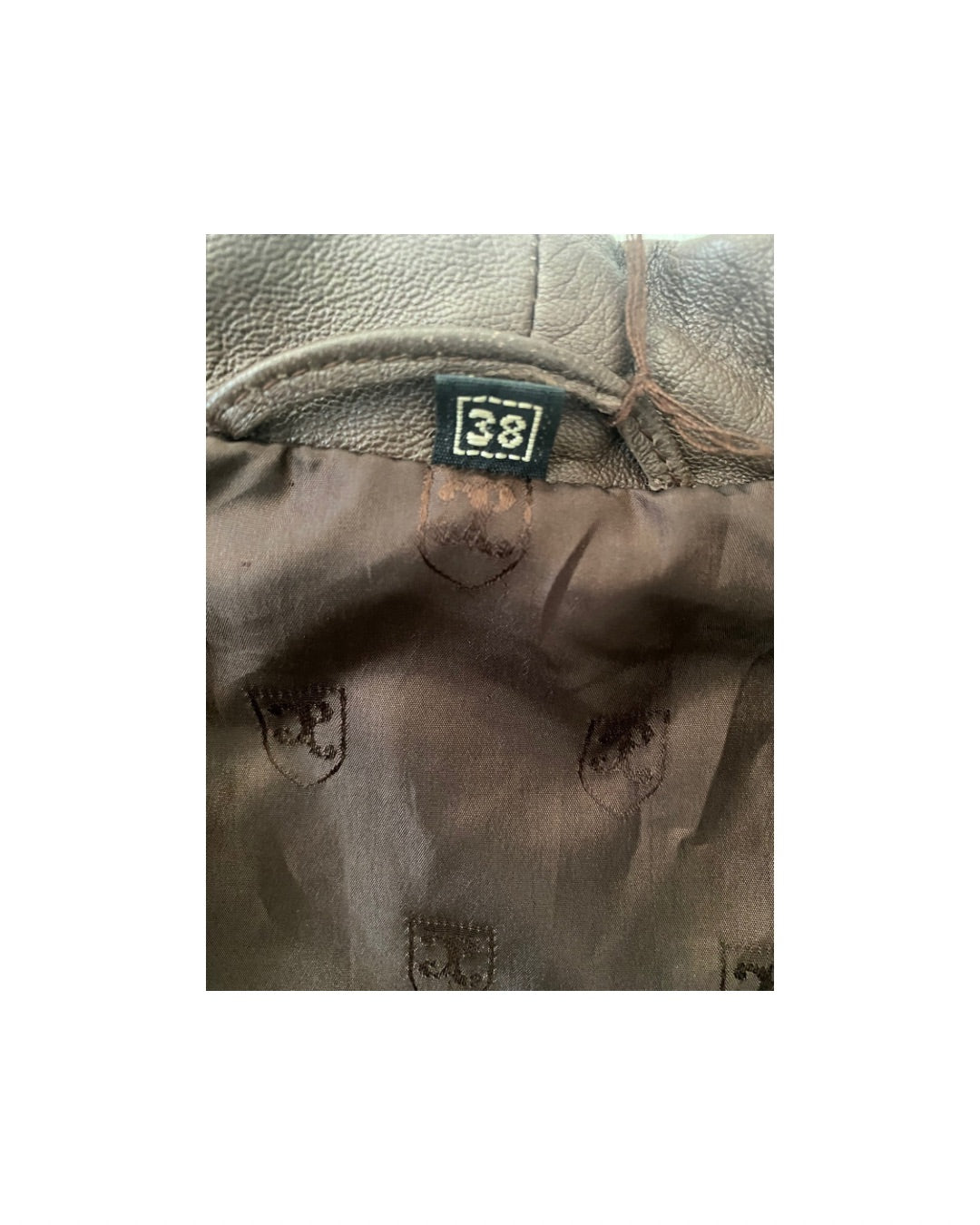Close-up of a brown leather jacket with a size tag on a white background