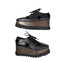 Black platform shoes with star details on a white background