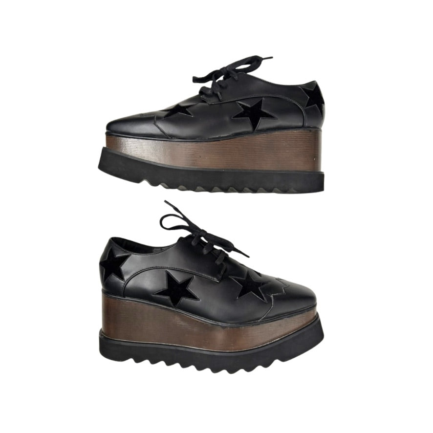 Black platform shoes with star details on a white background