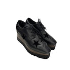 Black brogues with star designs on a white background