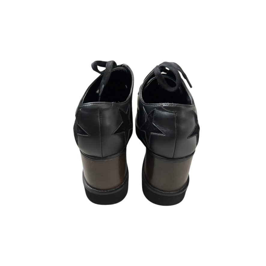 Pair of black wedge-heeled shoes on a white background