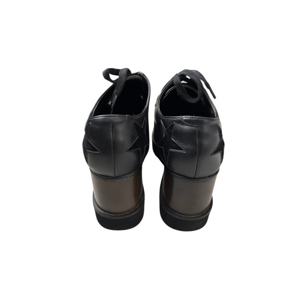 Pair of black wedge-heeled shoes on a white background