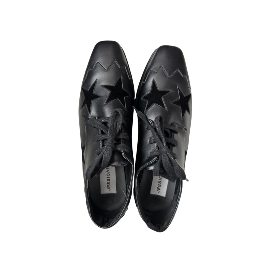 Pair of black shoes with star designs on a white background