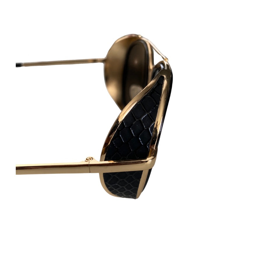 Gold and black quilted handbag on a white background