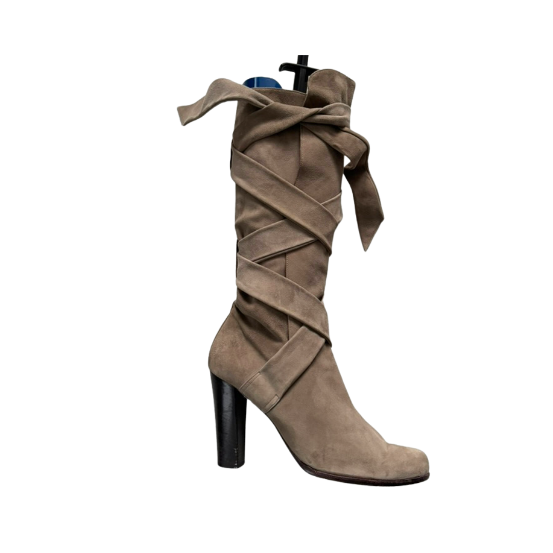 Beige knee-high boot with criss-cross design on a white background