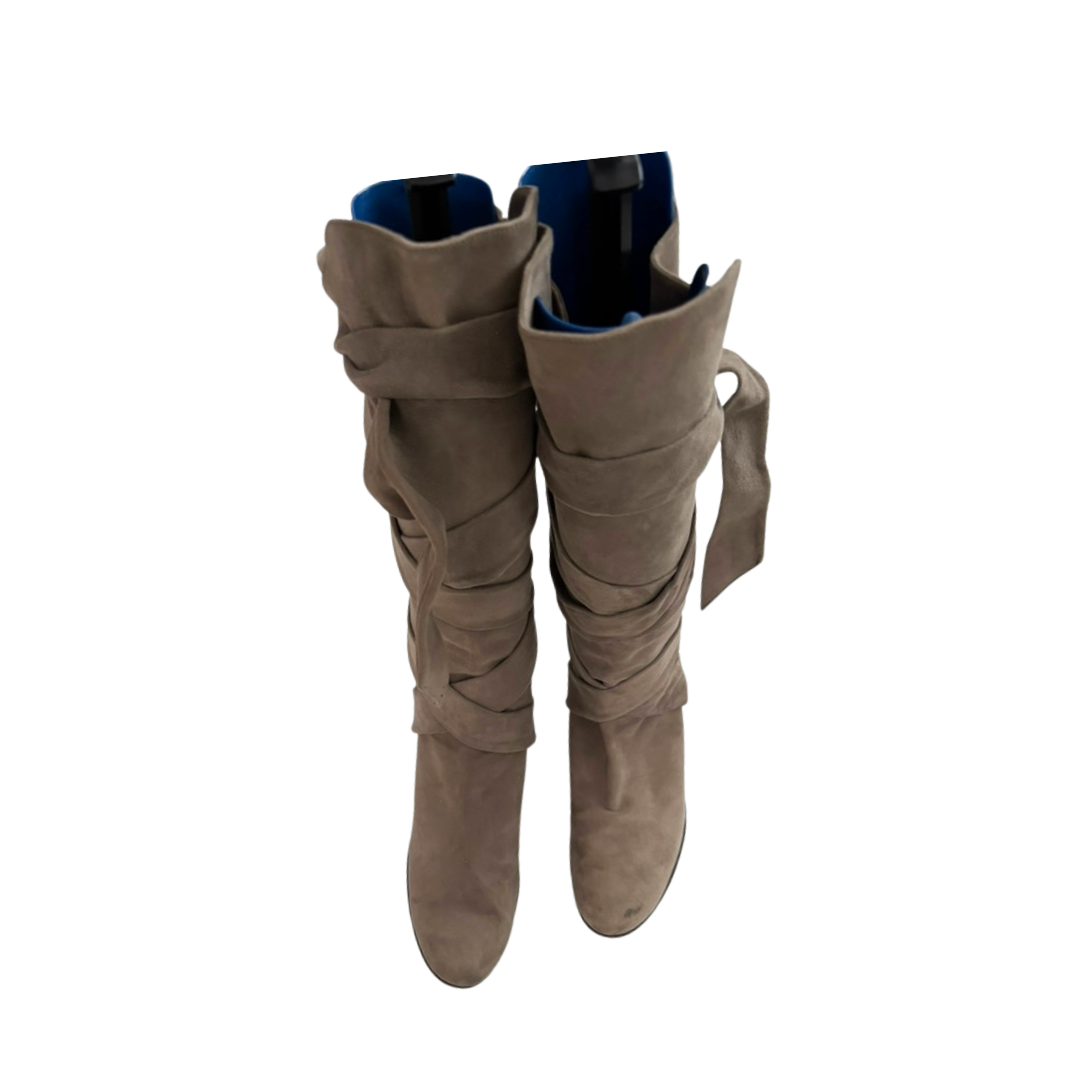 Pair of beige suede knee-high boots on a white background