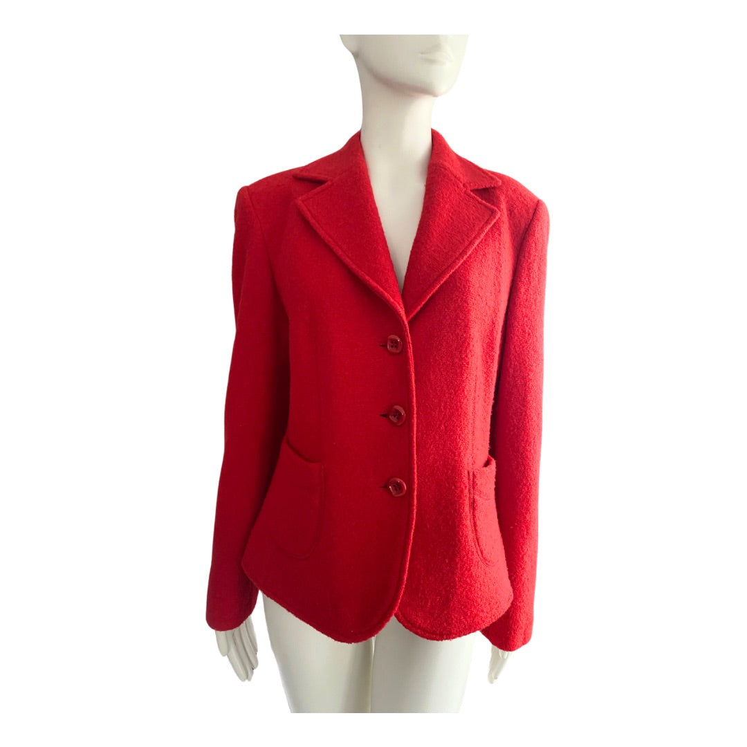 A red wool blazer with a classic lapel collar, three-button closure, and patch pockets, displayed on a mannequin.