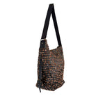 Textured handbag with brown strap on a white background