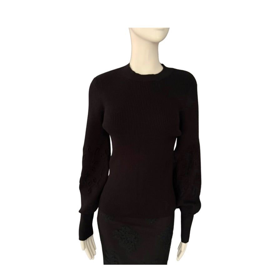Black sweater on a mannequin against a white background