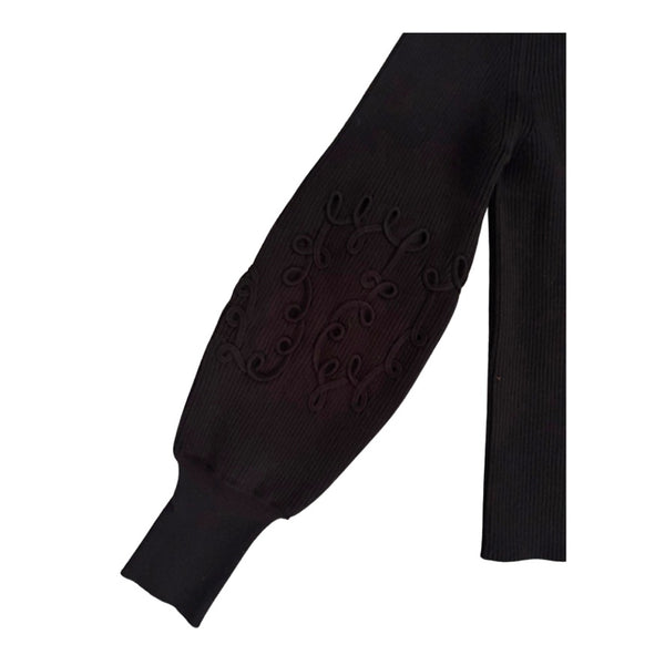 Black sweater sleeve with decorative cut-out pattern on a white background