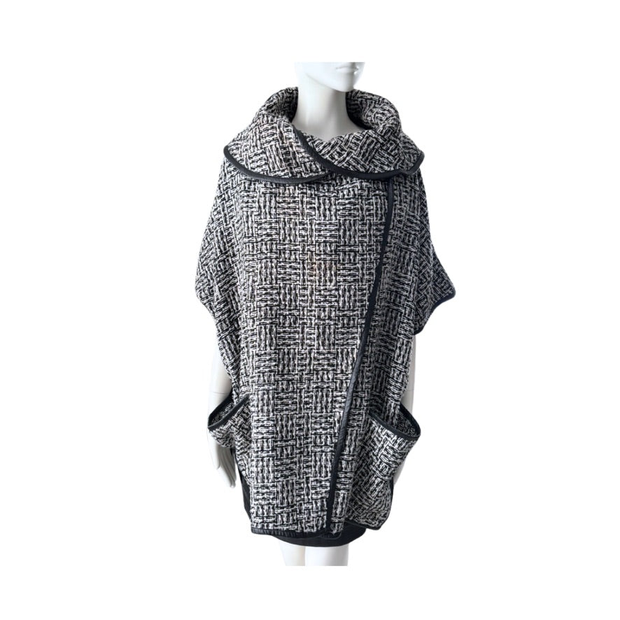 Black and white patterned poncho on a mannequin against a white background