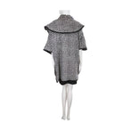 Mannequin wearing a black and white patterned poncho on a white background