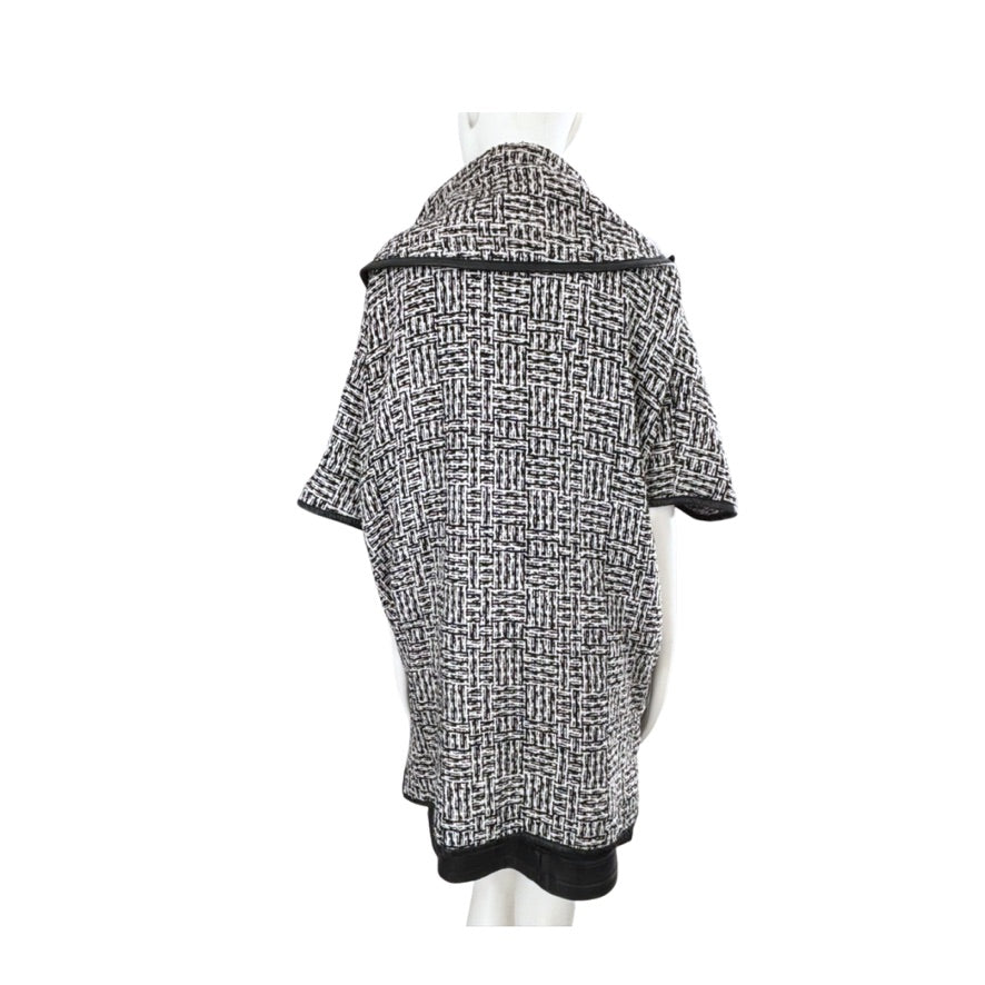 Black and white patterned coat on a mannequin against a white background