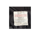 Clothing label on a black garment with text and symbols.