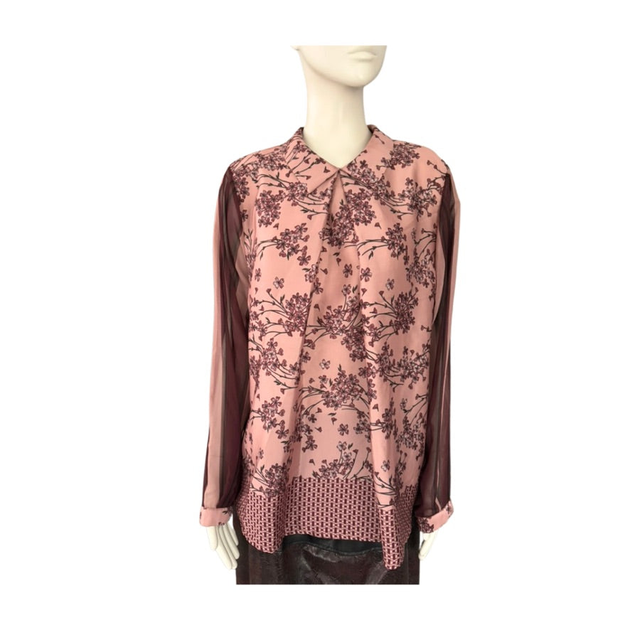 Mannequin wearing a pink floral blouse with brown sleeves on a white background