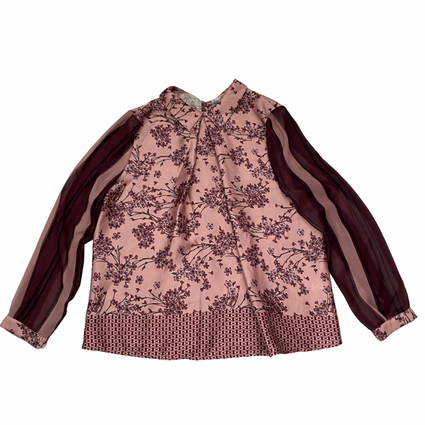 Pink floral blouse with brown accents on a white background
