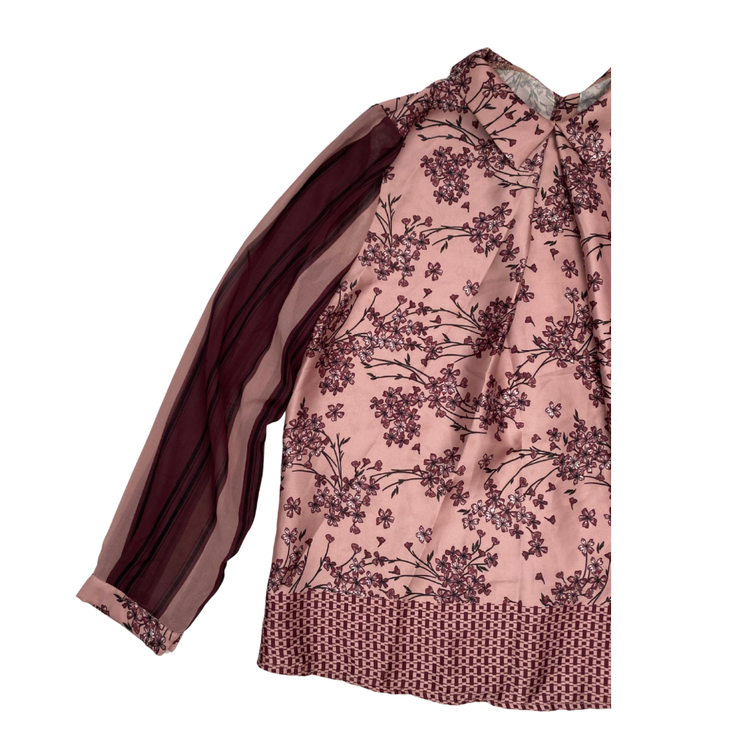 Pink blouse with floral pattern on a white background