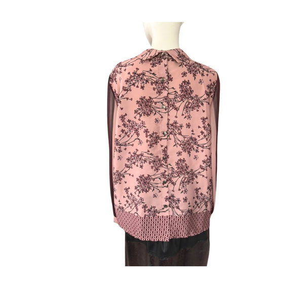 Pink floral blouse on a mannequin against a white background