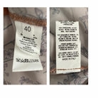 Two clothing labels with text and symbols on a fabric background