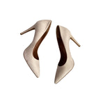 Pair of beige high-heeled shoes on a white background