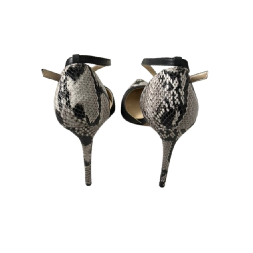 Pair of high-heeled shoes with snake print design on a white background