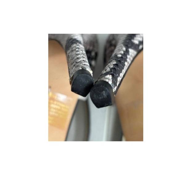 Close-up of a metallic hose with black connectors on a blurred background