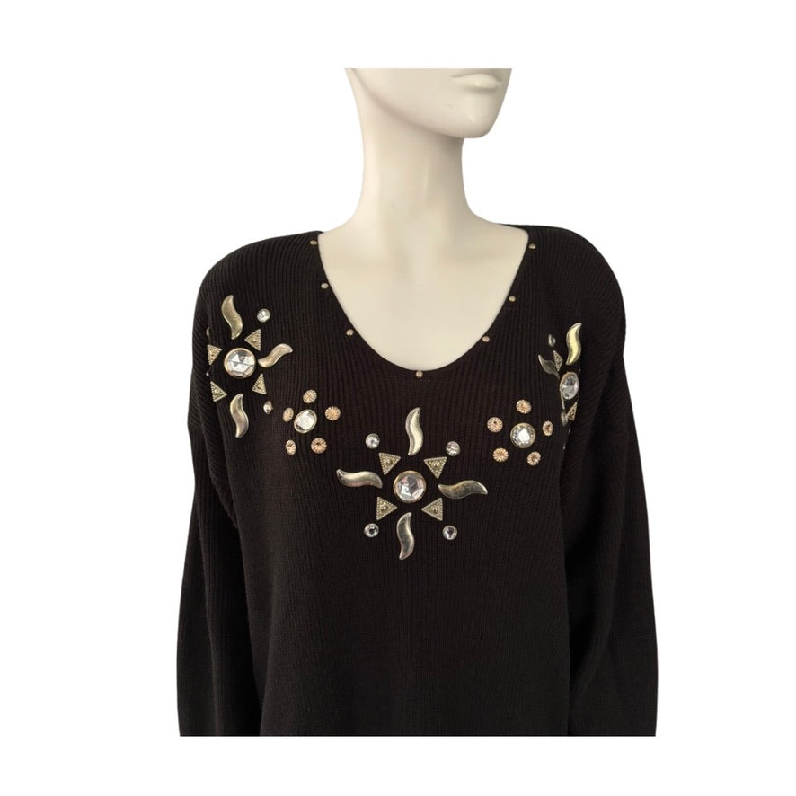 Black sweater with decorative elements on a mannequin against a white background