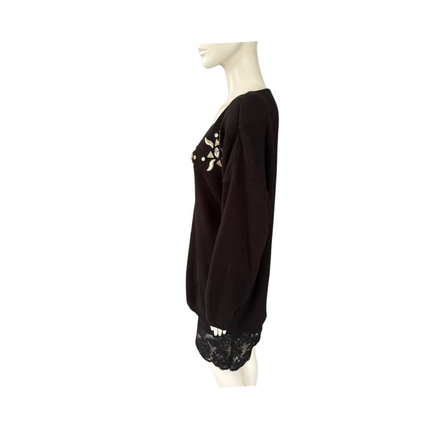 Black sweater with floral embellishments on a mannequin against a white background