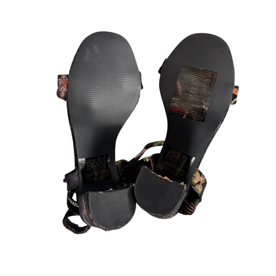 Black sandal with decorative straps on a white background